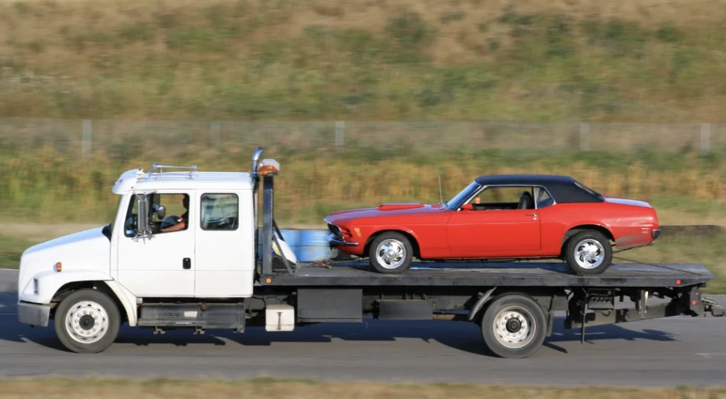 Flatbed Towing 4 classic red car loaded on the back of a flatbed tow truck